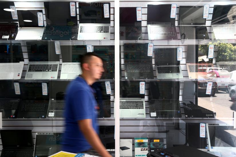 A man walks in front of a showcase displaying computers at a store in Mexico City, Mexico May 8, 2019. REUTERS
