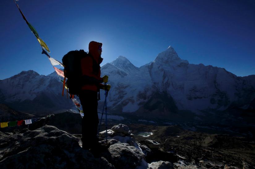 A trekker stands in front of Mount Everest, which is 8,850 meters high (C), at Kala Patthar in Solukhumbu District May 7, 2014. REUTERS/File Photo