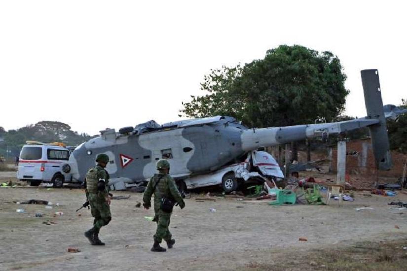 Soldiers of the Mexican army walk in front of the rugged military helicopter and van in Santiago Jamiltepec, Oaxaca state, Mexico, on February 17, 2018.