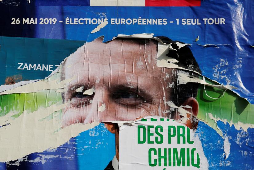 Torn and overlapping official posters of candidates for the 2019 European parliament elections including a poster of French President Emmanuel Macron as the cover for the Renaissance (Renewal) list, are seen in Cambrai, France, May 27, 2019. REUTERS