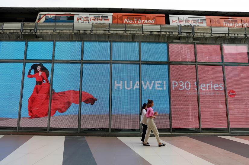 Women walk past a Huawei P30 advertising LED board at a shopping centre in Bangkok, Thailand May 22, 2019. REUTERS