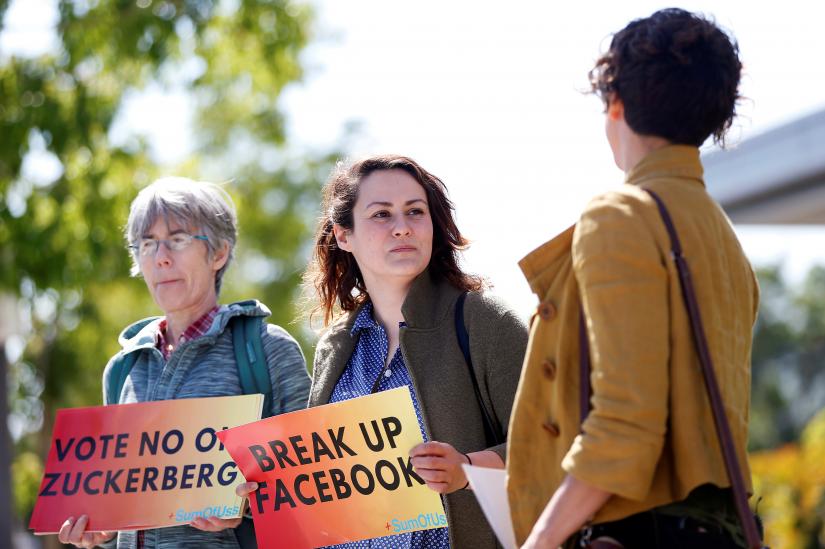 Arielle Cohen, a 30-year-old activist from Pittsburgh, PA., center, holds a sign during a protest outside the Facebook 2019 Annual Shareholder Meeting in Menlo Park, California, US, May 30, 2019. REUTERS