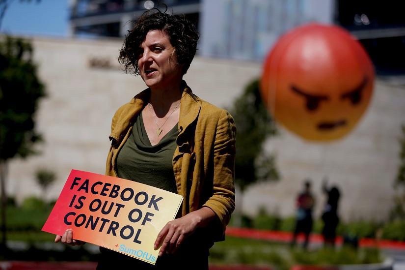 Leila Deen, program director at SumOfUs, holds a sign during a protest outside the Facebook 2019 Annual Shareholder Meeting in Menlo Park, California, US, May 30, 2019. REUTERS