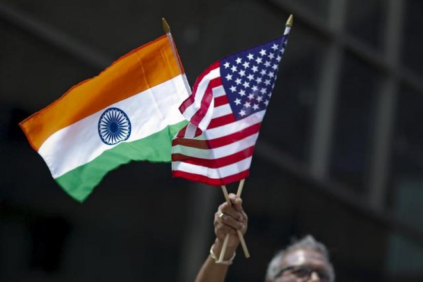 A man holds the flags of India and the US while people take part in the 35th India Day Parade in New York Aug 16, 2015. REUTERS/File Photo