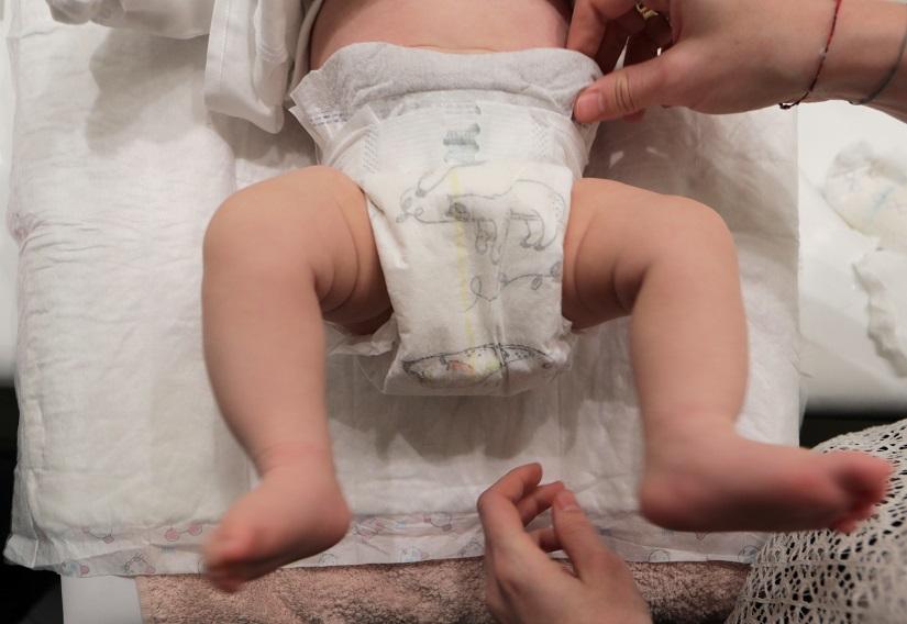A woman adjusts her baby`s diaper in Nice as a study by the French environment agency ANSES indicated that a variey of potentially toxic substances have been found in babies` nappies in France, January 23, 2019. REUTERS/File Photo