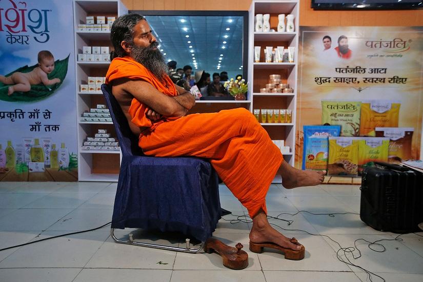 Indian yoga guru Baba Ramdev sits in front of a display of Patanjali products. REUTERS.