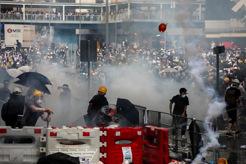 Protesters react to a tear gas during a demonstration against a proposed extradition bill in Hong Kong, China June 12, 2019. REUTERS