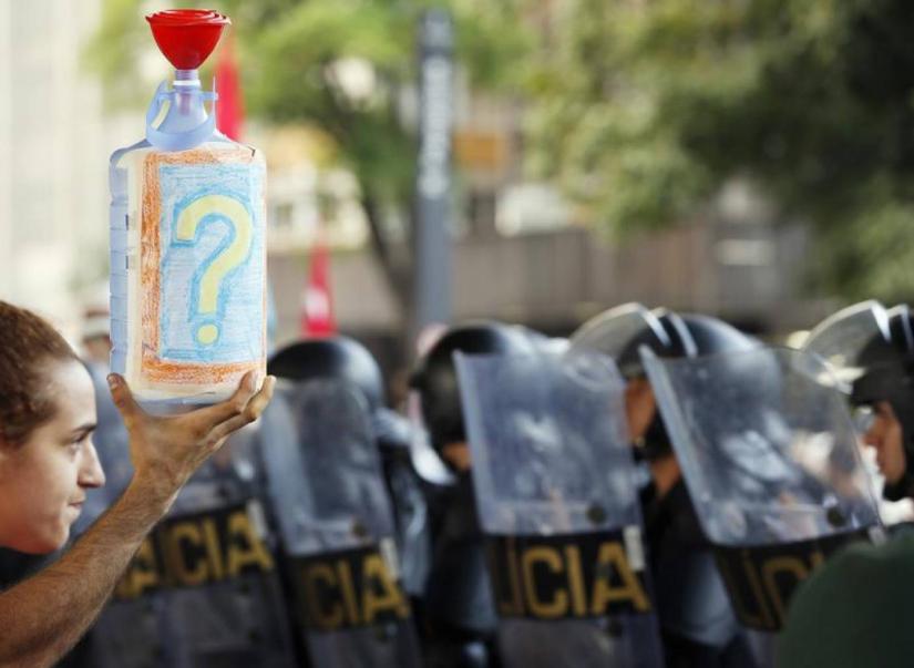 An empty water gallon is held up in front of a demonstrator during a protest against water rationing during a drought in Sao Paulo, Brazil, February 11, 2015. REUTERS/File Photo