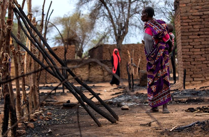 A woman looks at burnt houses during clashes between nomads and residents in Deleij village, located in Wadi Salih locality, Central Darfur, Sudan June 11, 2019. Picture taken June 11, 2019. REUTERS