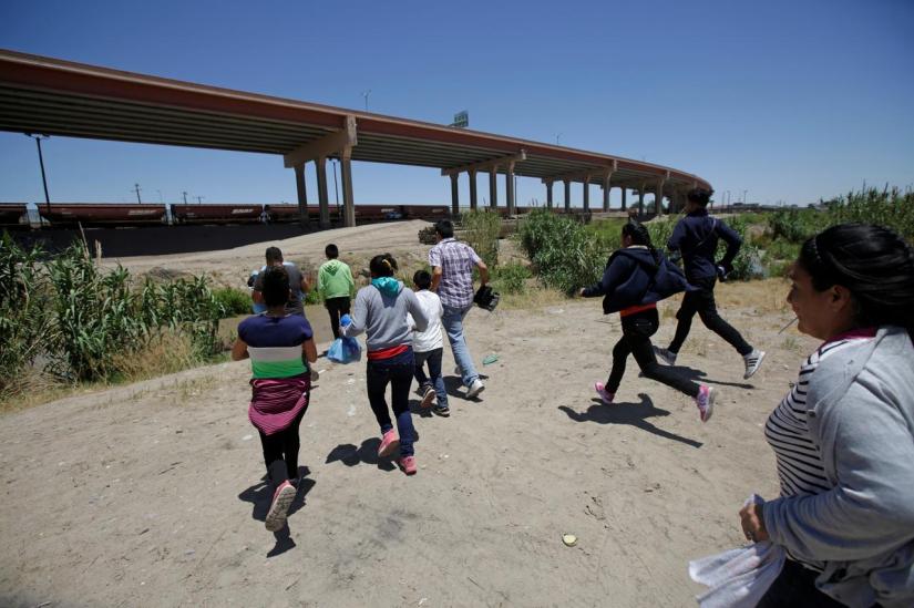 Migrants from Central America run towards the Rio Bravo river to cross and enter illegally into the United States to turn themselves in to request for asylum in El Paso, Texas, US, as seen from Ciudad Juarez, Mexico June 12, 2019. REUTERS