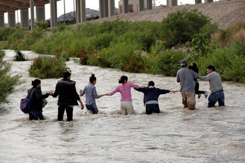 Migrants from Central America form a human chain to cross the Rio Bravo river to enter illegally into the United States to turn themselves in to request for asylum in El Paso, Texas, US, as seen from Ciudad Juarez, Mexico June 11, 2019. REUTERS/File Photo