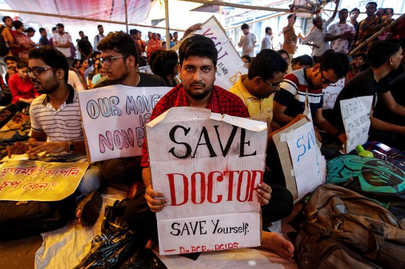 A doctor holds a placard at a government hospital during a strike demanding security after the recent assaults on doctors by the patients` relatives, in Kolkata, India, June 14, 2019. REUTERS