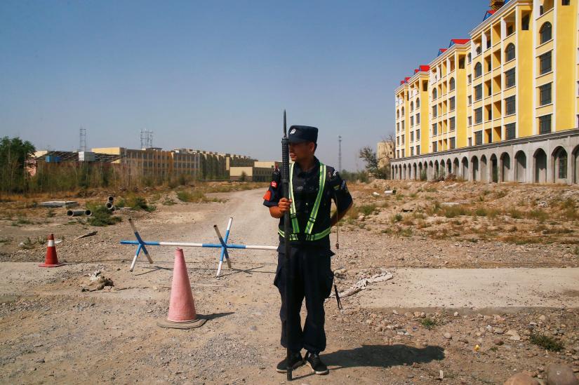 A Chinese police officer takes his position by the road near what is officially called a vocational education centre in Yining in Xinjiang Uighur Autonomous Region, China September 4, 2018. REUTERS/File Photo