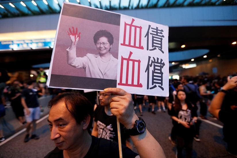A protester holds a placard depicting Hong Kong Chief Executive Carrie Lam during a demonstration demanding Hong Kong`s leaders to step down and withdraw the extradition bill, in Hong Kong, China, June 16, 2019. REUTERS