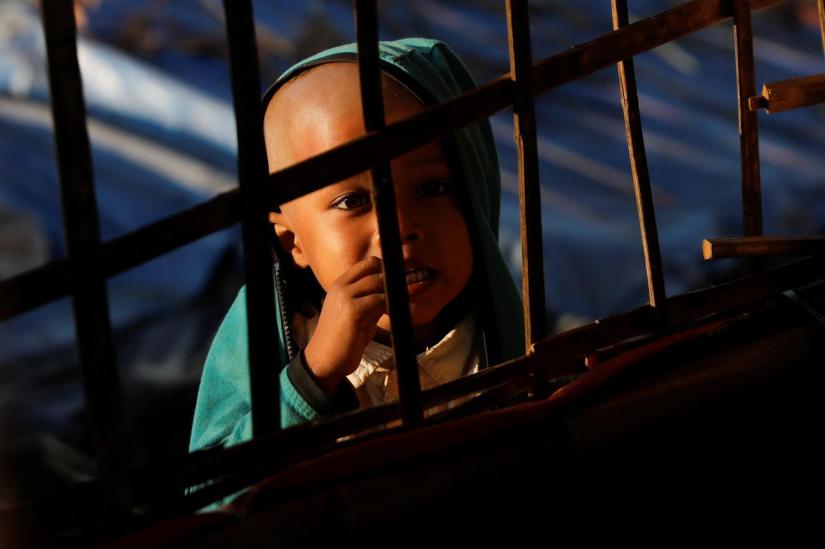 A Rohingya refugee child looks at others studying at a makeshift madrasa at the Burma Para refugee camp near Cox`s Bazar, Bangladesh Dec 27, 2017. REUTERS/File Photo