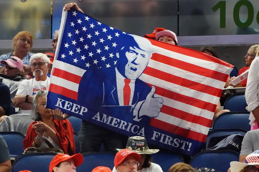 People sit in the stands with a flag before a rally for U.S. President Donald Trump at the Amway Center in Orlando, Florida, U.S., June 18, 2019. REUTERS