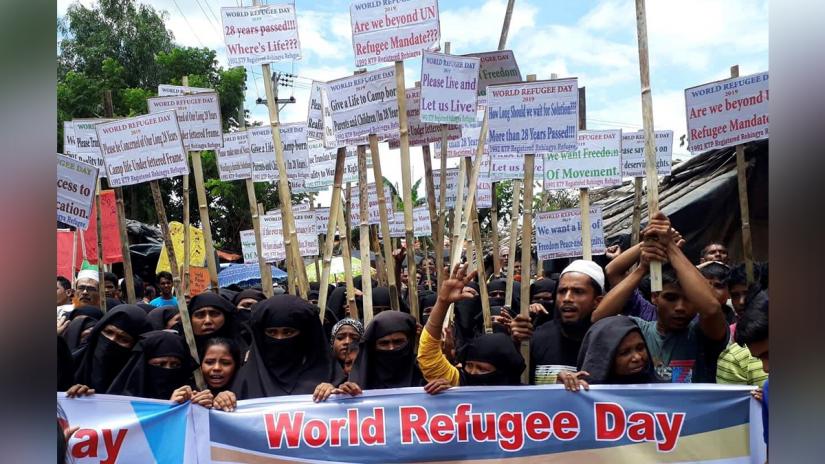 Rohingya refugees hold placards as they participate in a rally to observe World Refugee Day at the Rohingya refugee camp in Cox's Bazar, Bangladesh, June 20, 2019. REUTERS