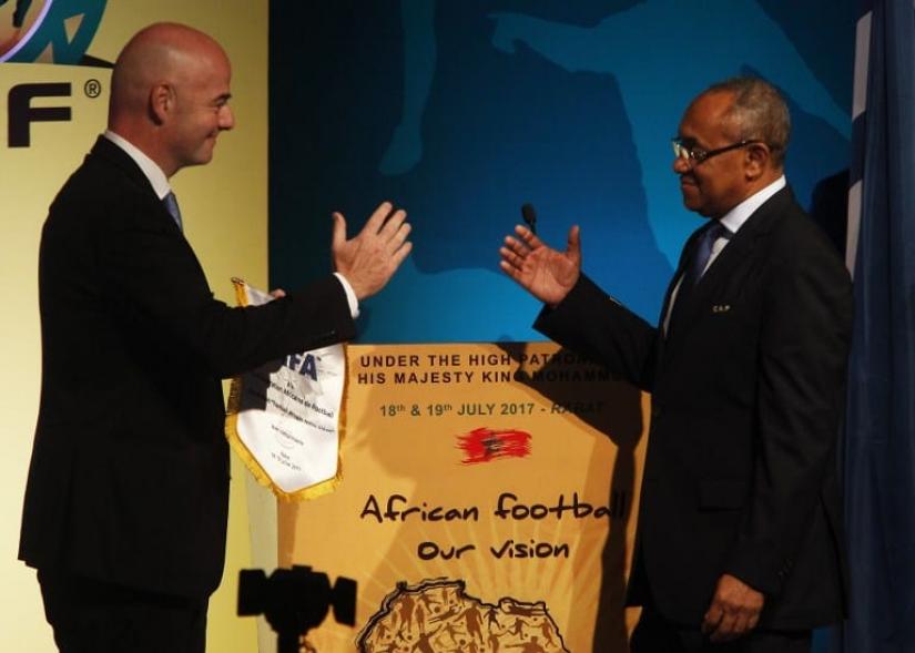 File Photo: FIFA President Gianni Infantino (L) shakes hands with president of the African Football Confederation (CAF) Ahmad Ahmad during the first ever African Football Symposium in Skhirat on the outskirts of the Moroccan capital on July 18, 2017. Delegates from CAF`s 55 member federations, coaches, retired players as well as top football officials from FIFA are in the Moroccan capital to discuss, among other issues, the future of African Cup of Nations, including its format and timing.