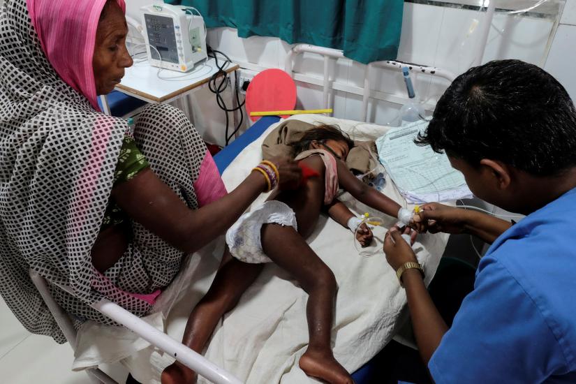 A child suffering from acute encephalitis syndrome is treated by a doctor at a hospital in Muzaffarpur, in the eastern state of Bihar, India, June 20, 2019. REUTERS