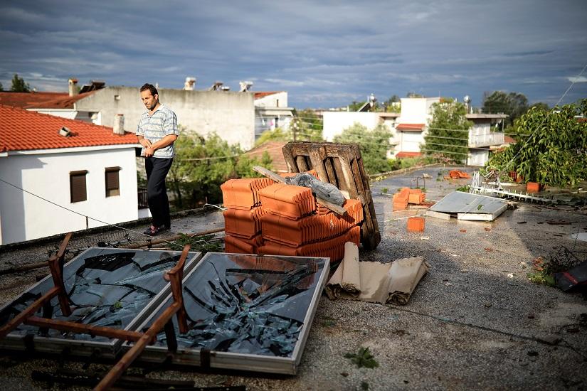 A man walks on a damaged terrace following heavy storms at the village of Nea Plagia, Greece, July 11, 2019. REUTERS