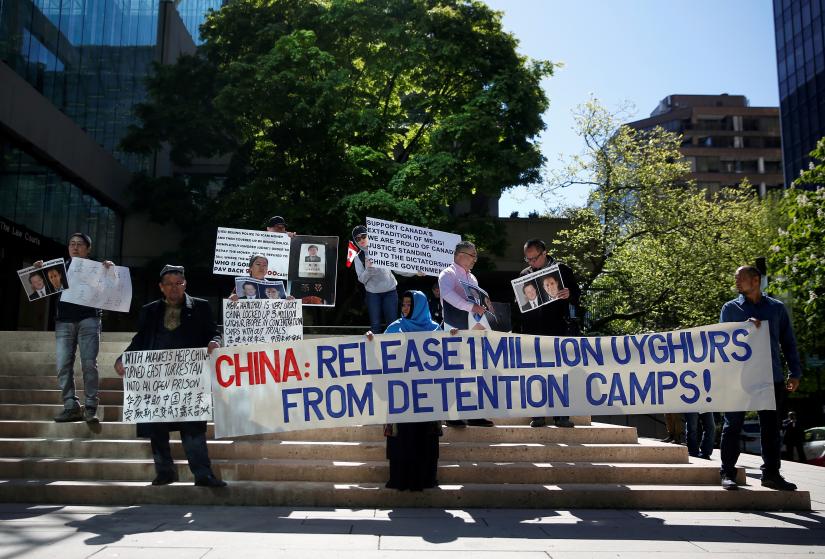 People hold signs protesting China`s treatment of Uighur people in the Xinjiang region, in Vancouver, British Columbia, Canada, May 8, 2019. REUTERS/File Photo