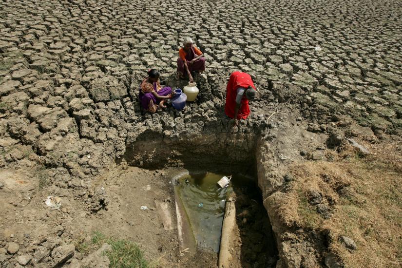 Women fetch water from an opening made by residents at a dried-up lake in Chennai, India, June 11, 2019. REUTERS/File Photo