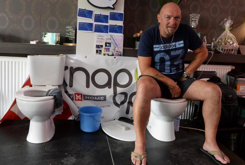 Belgian Jimmy de Frenne sits on a toilet in a cafe in an attempt to enter the Guinness Book of Records for a new record for sitting on a toilet for the longest time, in Ostend, Belgium, July 11, 2019. REUTERS
