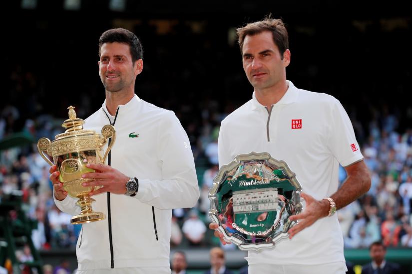 Tennis - Wimbledon - All England Lawn Tennis and Croquet Club, London, Britain - July 14, 2019 Serbia`s Novak Djokovic celebrates winning the final as he and Switzerland`s Roger Federer pose with their trophies REUTERS