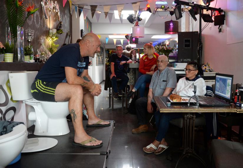 Belgian Jimmy de Frenne sits on a toilet in a cafe in an attempt to enter the Guinness Book of Records for a new record for sitting on a toilet for the longest time, in Ostend, Belgium, July 11, 2019. Picture taken July 11, 2019. REUTERS