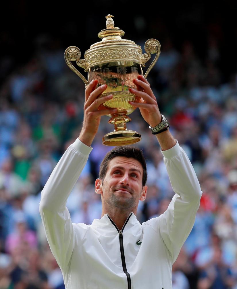 Tennis - Wimbledon - All England Lawn Tennis and Croquet Club, London, Britain - July 14, 2019 Serbia`s Novak Djokovic poses with the trophy as he celebrates winning the final against Switzerland`s Roger Federer REUTERS