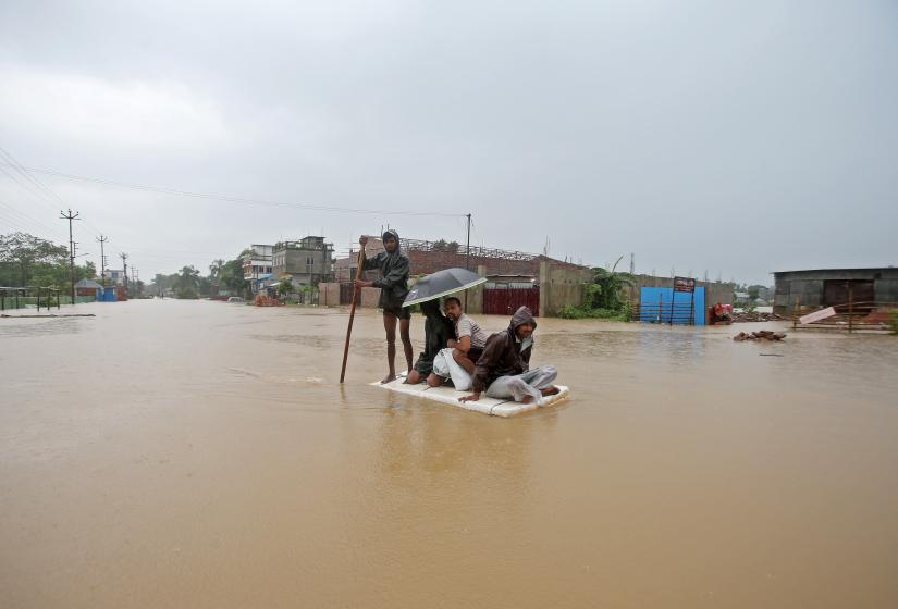 Villagers use a makeshift raft to cross a flooded area on the outskirts of Agartala, India July 15, 2019. REUTERS