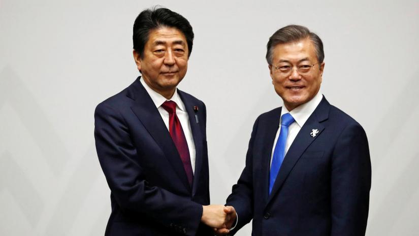 South Korean President Moon Jae-in shakes hands with Japanese Prime Minister Shinzo Abe during their meeting in Pyeongchang, South Korea Feb 9, 2018. REUTERS/File Photo