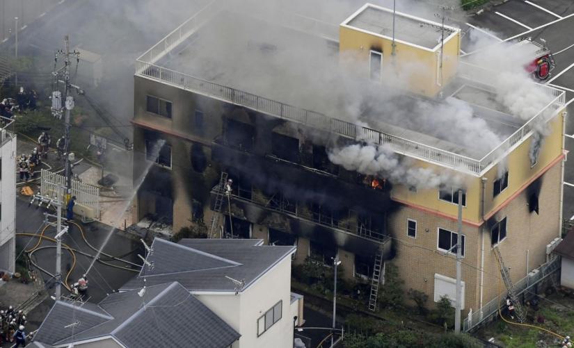 An aerial view shows firefighters battling fires at the site where a man started a fire after spraying a liquid at a three-story studio of Kyoto Animation Co. in Kyoto, western Japan, in this photo taken by Kyodo, July 18, 2019. Mandatory credit Kyodo/via REUTERS