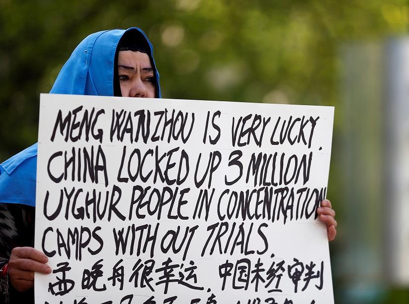 Dilibair Yusuf holds a sign protesting China`s treatment of Uighur people in the Xinjiang region during a court appearance by Huawei`s Financial Chief Meng Wanzhou, outside of British Columbia Supreme Court building in Vancouver, British Columbia, Canada, May 8, 2019. REUTERS/File Photo