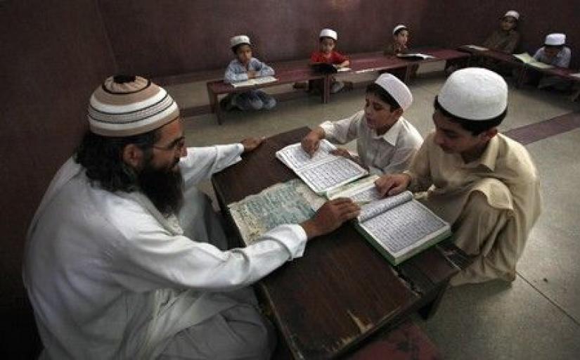 A teacher guides students in reciting verses from the Koran at Sunehri (golden) mosque, a religious seminary in Peshawar, Pakistan. File Photo
