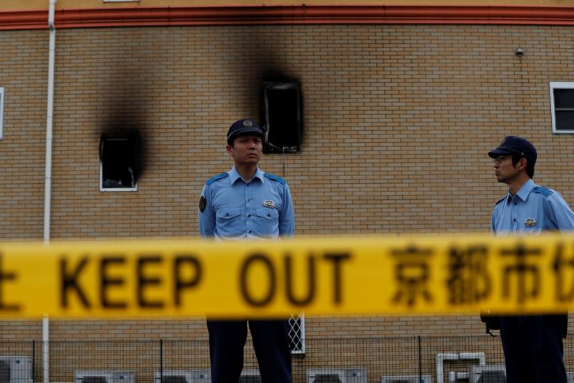 Policemen stand behind a police line at the torched Kyoto Animation building in Kyoto, Japan, July 20, 2019. REUTERS
