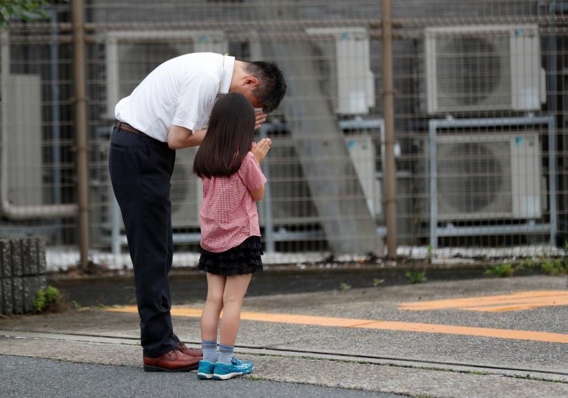 People pray for victims of the torched Kyoto Animation building in Kyoto, Japan, July 20, 2019. REUTERS