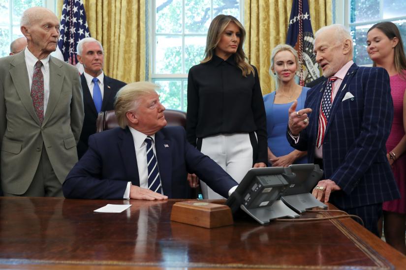 U.S. President Donald Trump listens to Apollo 11 Lunar Module Pilot Buzz Aldrin as Apollo 11 Command Module Pilot Michael Collins, Vice President Mike Pence, first lady Melania Trump and guests look on during an Apollo 11 50th anniversary commemoration event in the Oval Office of the White House in Washington, U.S., July 19, 2019. REUTERS