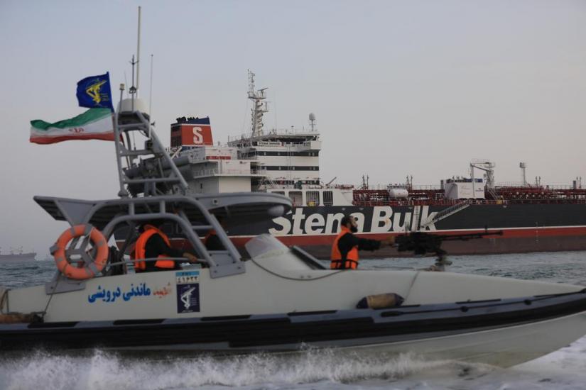 A boat of Iranian Revolutionary Guard sails next to Stena Impero, a British-flagged vessel owned by Stena Bulk, at Bandar Abbas port, in this undated handout photo. Iran, ISNA/WANA Handout via REUTERS