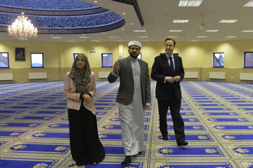 Britain`s Prime Minister David Cameron (R) speaks with imam Qari Asim (L), and Shabana Muneer, a member of the mosque`s women`s group, as he visits the Makkah Masjid Mosque in Leeds, Britain January 18, 2016. REUTERS/File Photo