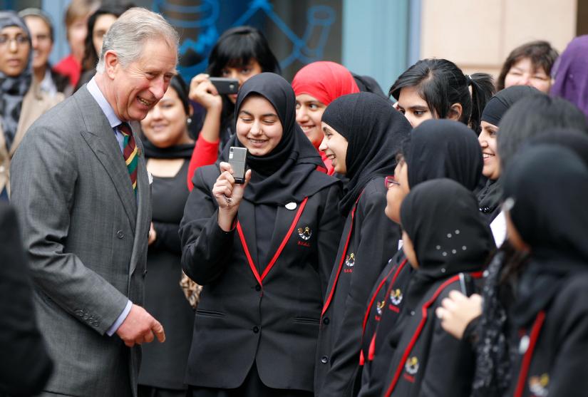 Prince Charles laughs with pupils as he leaves Belle Vue Girls School in Bradford, northern England.