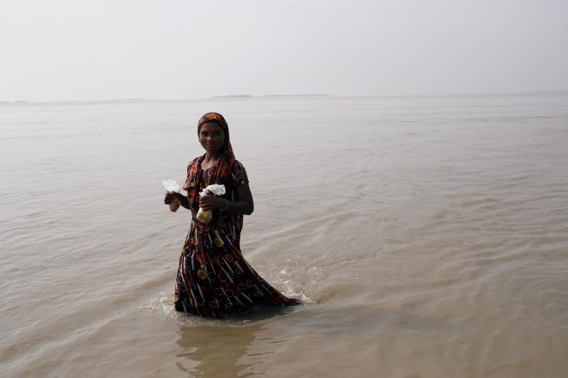 A flood-affected woman wades through flooded area in Jamalpur, Bangladesh July 21, 2019. REUTERS