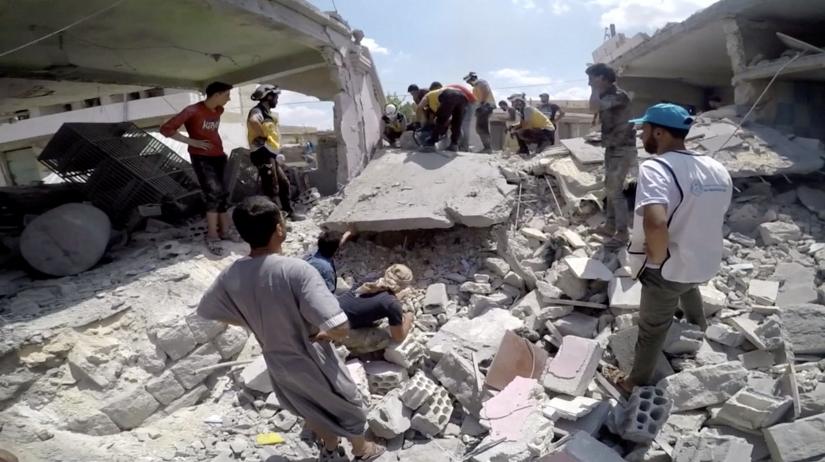 A White Helmets member uses a saw on rubble after an airstrike in this screen grab taken from a social media video said to be taken in Idlib, Syria on July 16, 2019. Picture taken July 16, 2019. White Helmets/social media via REUTERS