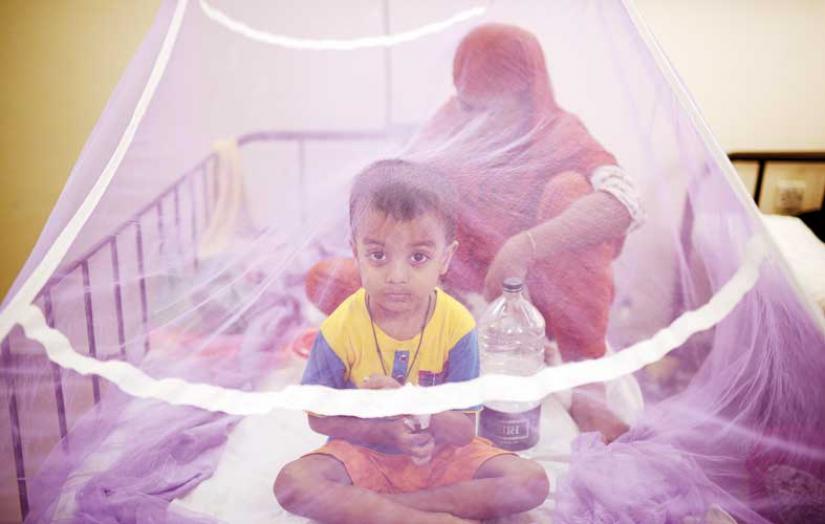 A mother and child diagnosed with dengue are seen inside a mosquito net in this photo taken recently from the Bangladesh Shishu Hospital in Dhaka. FILE PHOTO/Mahmud Hossain Opu