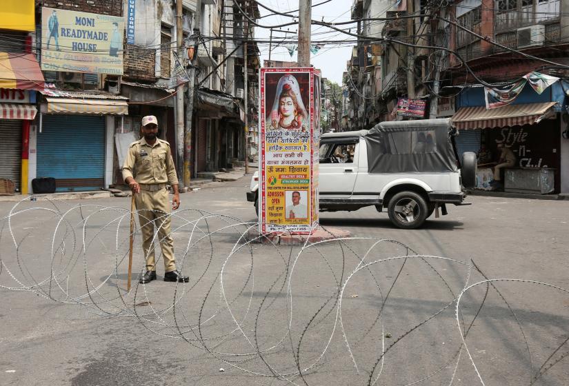 An Indian security personnel stands guard along a deserted street during restrictions in Jammu, August 5, 2019. REUTERS