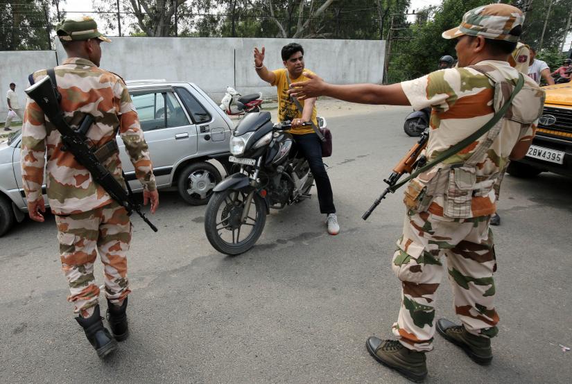 Members of Central Industrial Security Force (CISF) stop a man at a check point along a road during restrictions in Jammu August 6, 2019. REUTERS