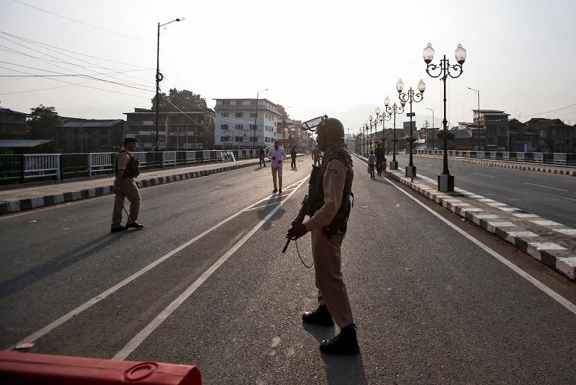 Indian security personnel stand guard on a deserted road during restrictions in Srinagar, Aug 5, 2019. REUTERS