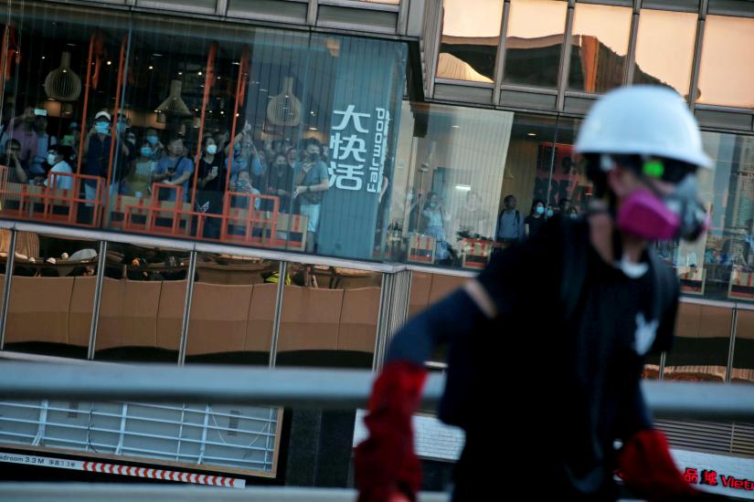 Restaurant customers watch from a window as demonstrators clash with Hong Kong police in Hardcourt Road, Admiralty, in Hong Kong, China, August 5, 2019. REUTERS