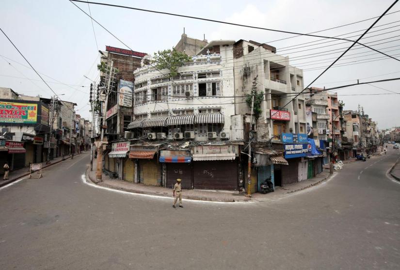 Indian policemen stand guard in a deserted street during restrictions in Jammu August 6, 2019. REUTERS