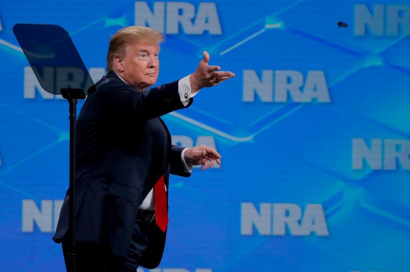 FILE PHOTO: U.S. President Donald Trump tosses a pen to the crowd after signing an executive order as he announces that the United States will drop out of the Arms Trade Treaty signed during the Obama administration during a speech at the National Rifle Association-Institute for Legislative Action`s (NRA-ILA) 148th annual meeting in Indianapolis, Indiana, U.S., April 26, 2019.REUTERS